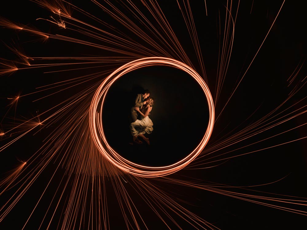 Drone portrait that soars of bride and groom with copper and neon lighting.