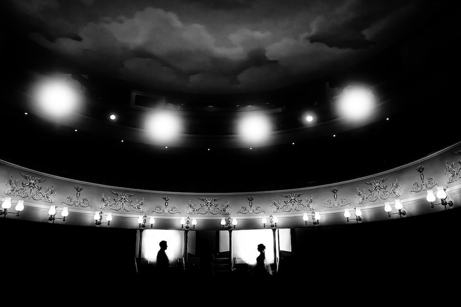 bride and groom in black and white photo standing in windowless wedding venue.