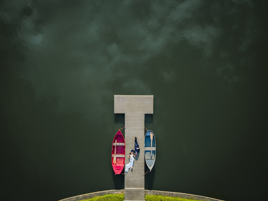 wedding couple lying on the pier next to rowboats won the 2022 WPPI award.