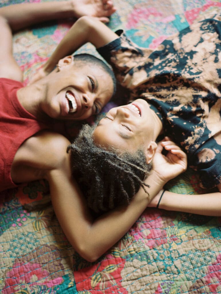 Mother and child lie down and laugh.