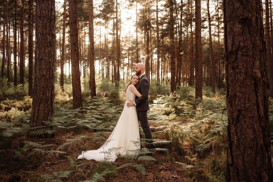 bride and groom hugging in forest.