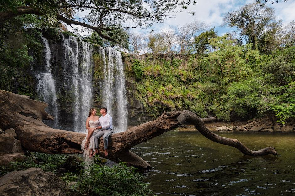 couple on log by waterfall