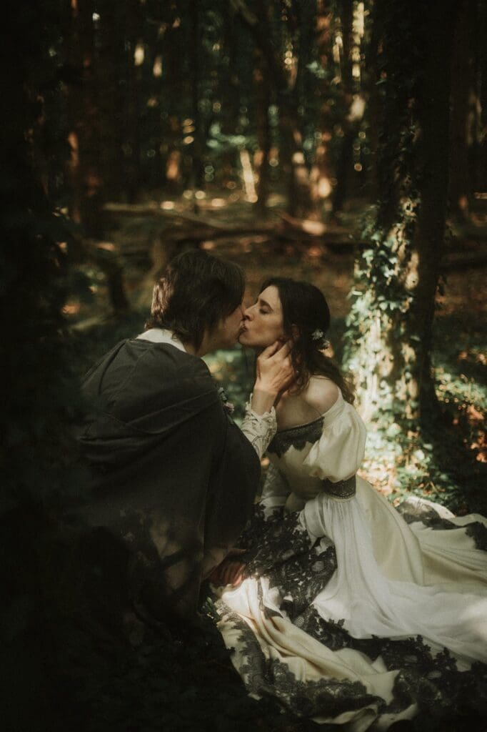 couple kissing in forest.