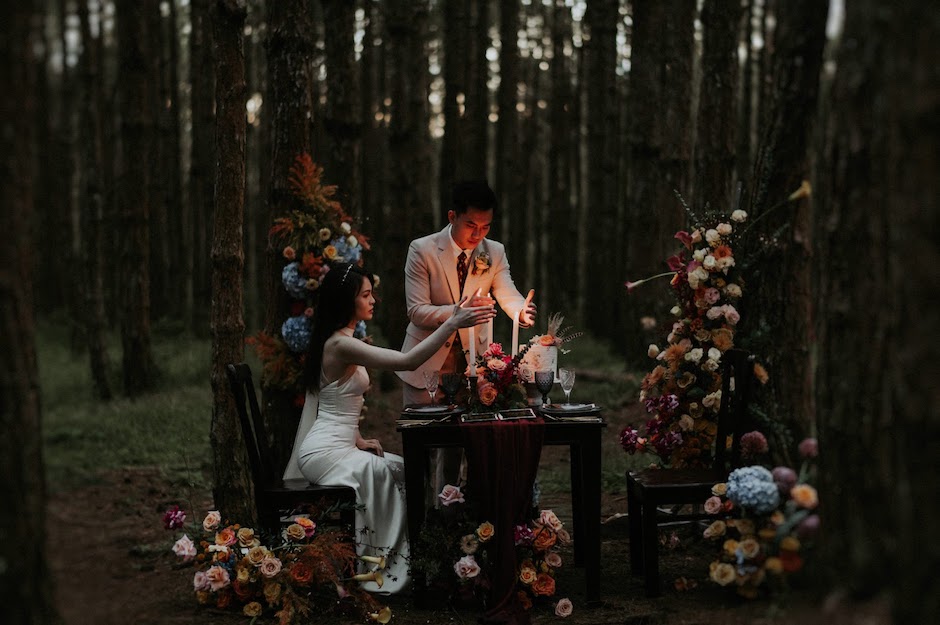 bride and groom having dinner in forest.