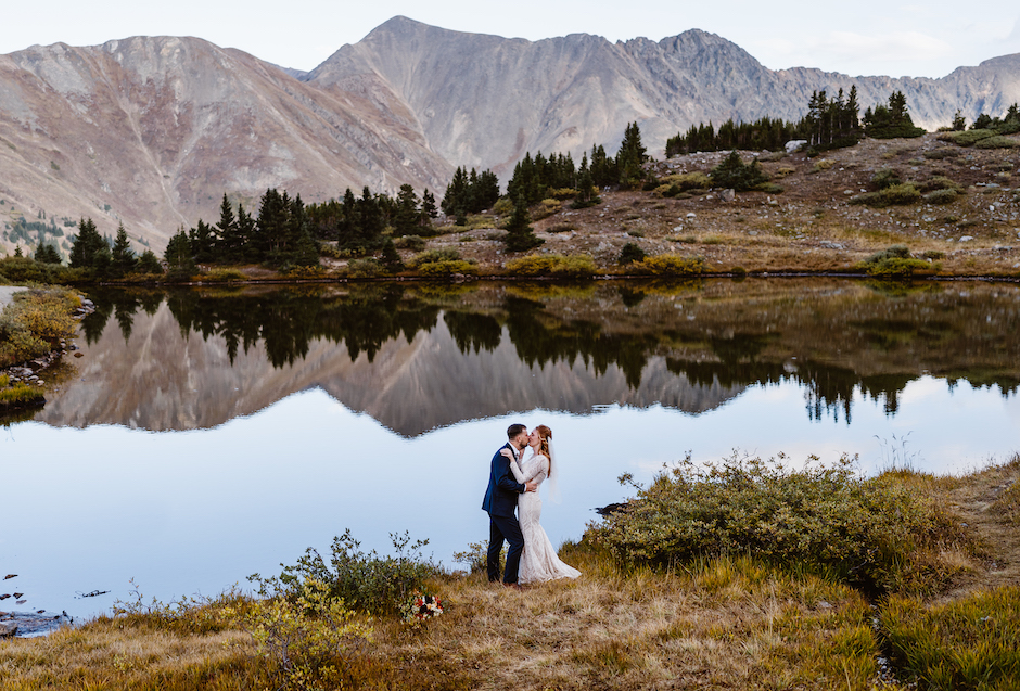 Alpine Vows wedding portrait of couple by. lake,