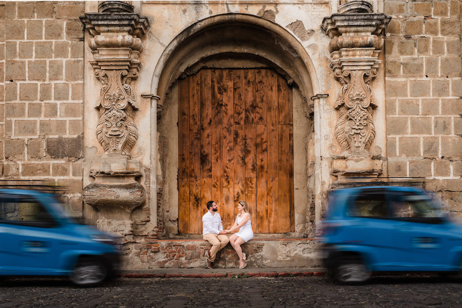 couple sitting in front of massive building.