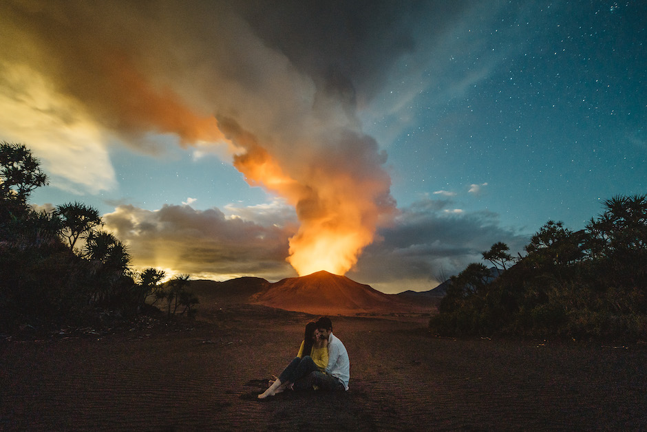 tender photo moment with volcanic eruption in background.