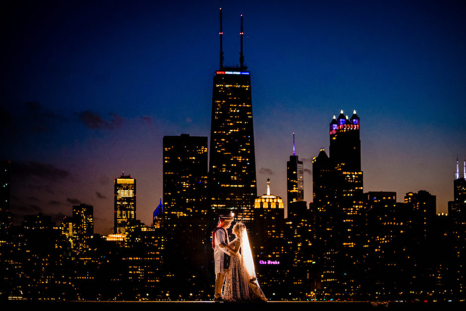 Indian wedding couple against city backdrop.