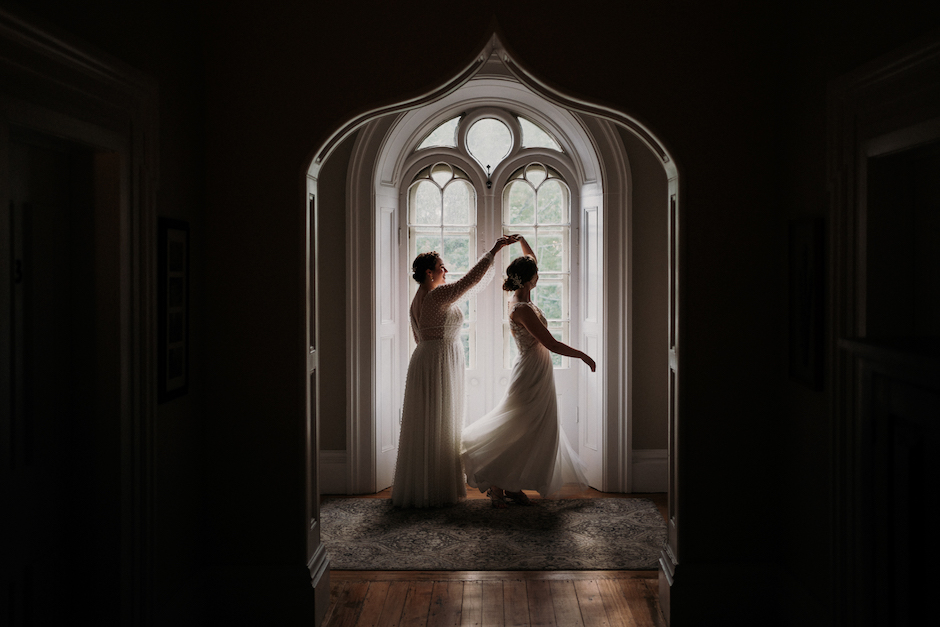 two brides twirling in window frame.