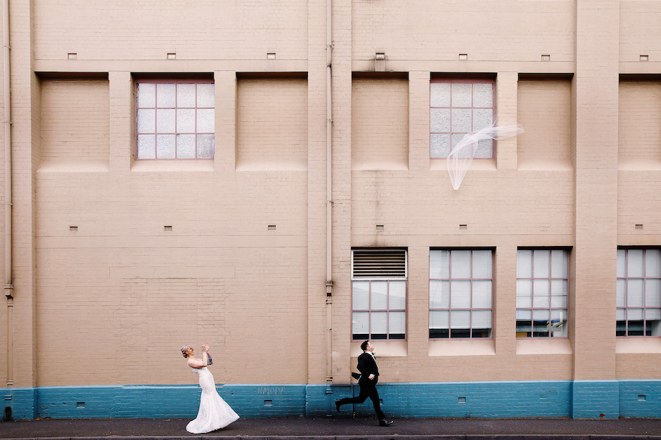bride and groom run after veil flying away.