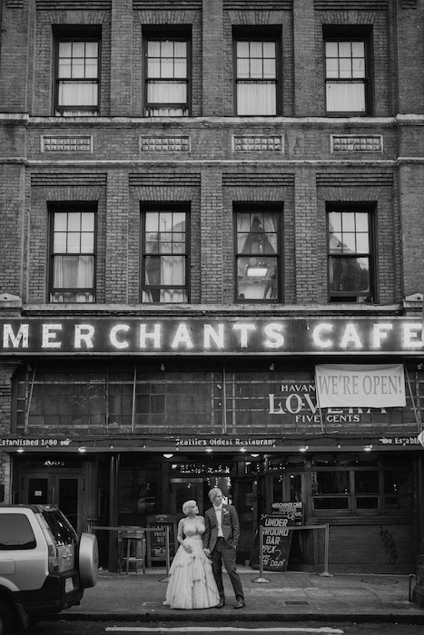bride and groom in front of cafe in black and white.
