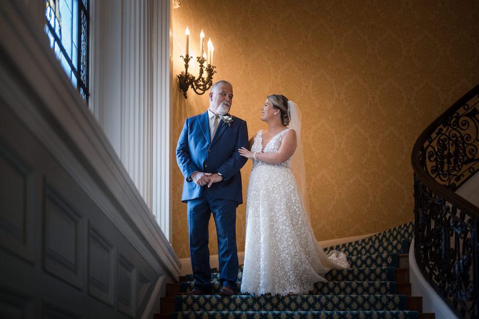 Bride and her father walking down staircase.